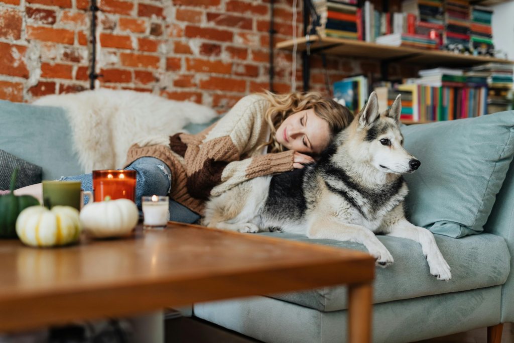 Persona recostada de perro en sofa